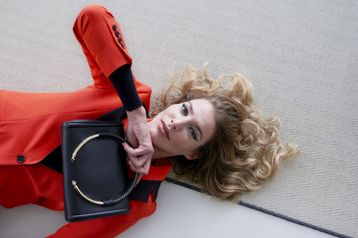 Elegant woman showcasing a PK1 Milano leather handbag