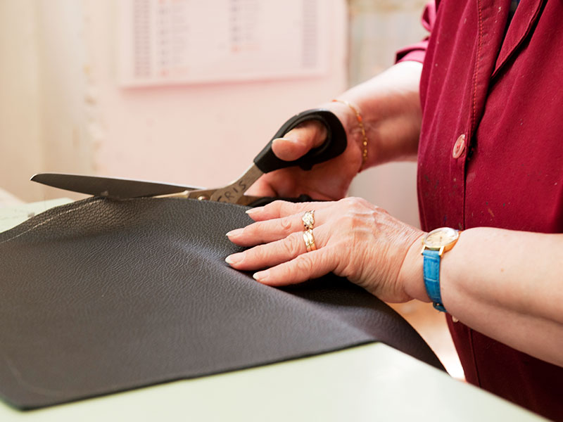 Close-up of an artisan stitching leather at PK1 Milan