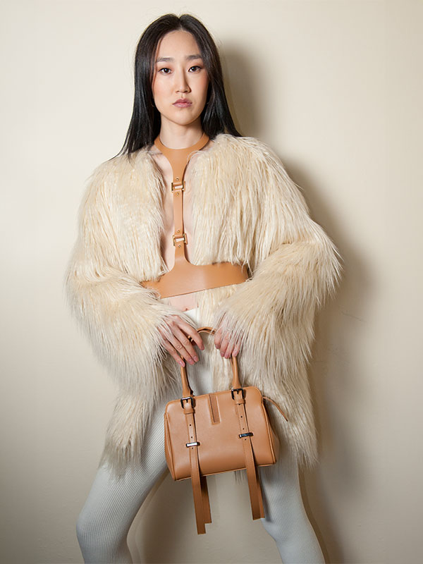 Model showcasing an elegant leather bag, highlighting the finished product from PK1 Milano consulting services